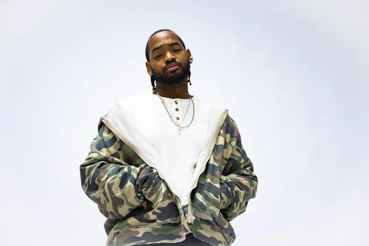 RaSean Parks in a camo zip jacket, hands in the pockets, looking down at the camera